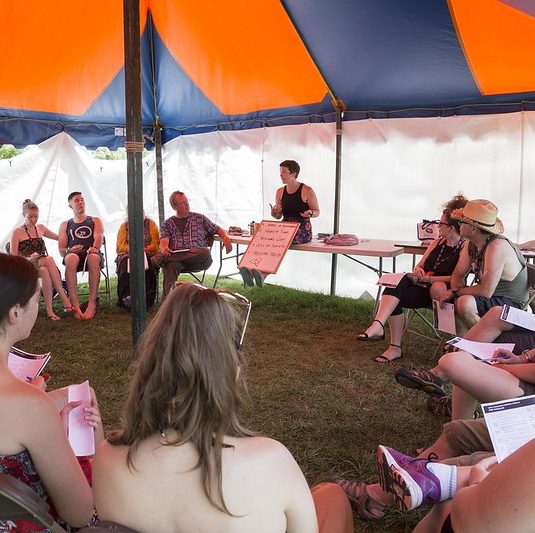 People gathered in a festival tent for discussion